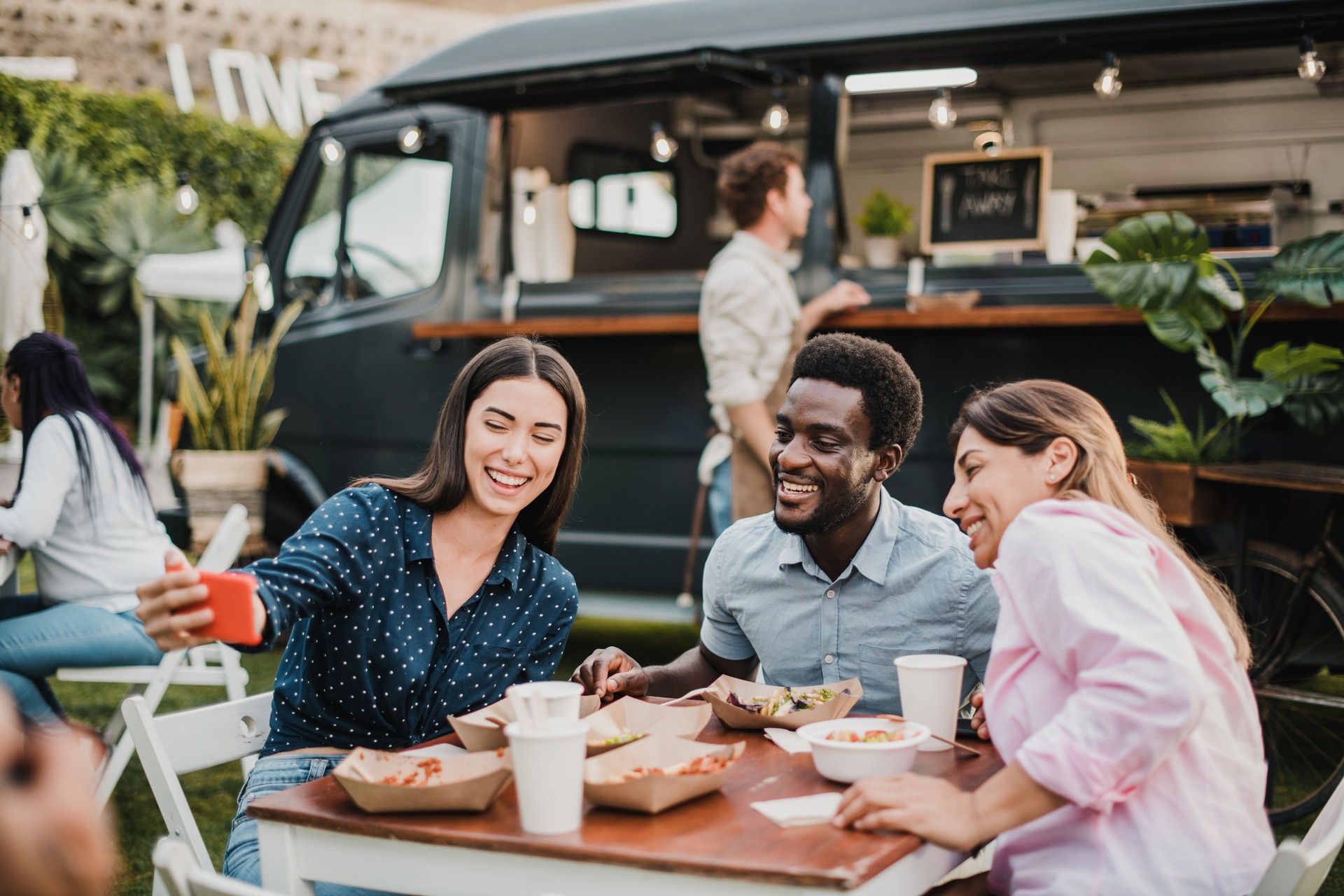Multiracial people having fun doing selfie at food truck outdoor - Focus on african man face