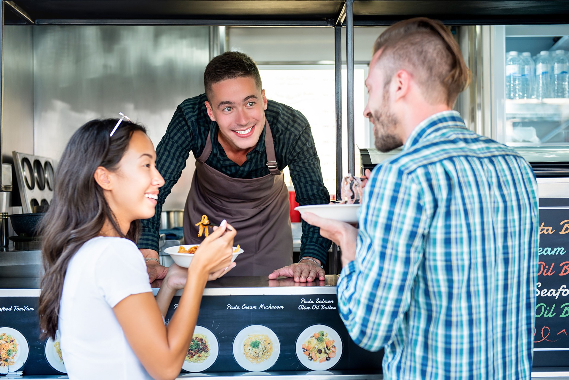 Tourist couple enjoy eating pasta from food truck